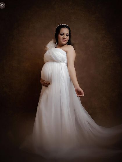 This solo portrait in a white gown has a soft, dreamy quality. The pose and the flowing fabric work together to create an image that is both graceful and emotive.