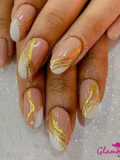 A chic and sophisticated design. We used a soft nude base with a clean white accent, and then added elegant, sweeping lines of gold and gold glitter for a look that is both modern and timeless.