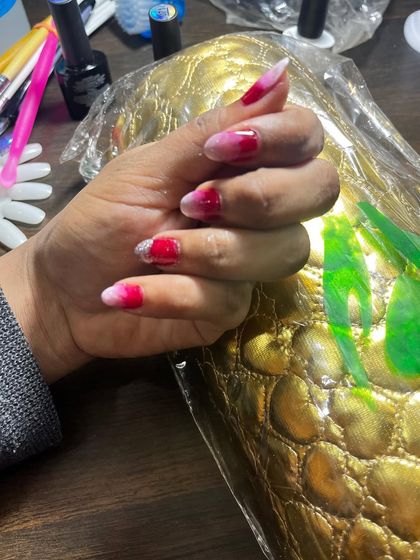 A close-up of the finished red and pink ombré nails. This is a bold and beautiful color combination that really makes a statement.