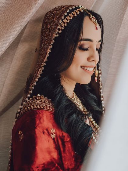 A beautiful close-up of a bride with her eyes closed, smiling softly. This portrait captures a moment of serene happiness.