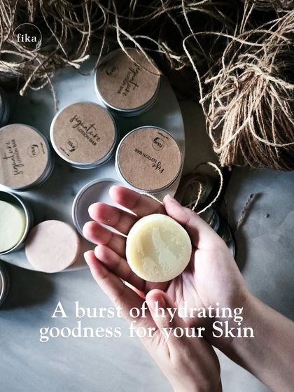A burst of hydrating goodness for your skin. My mini solid lotion bars are held in hand, showing their convenient size. They are perfect for a quick, natural pick-me-up for dry skin.