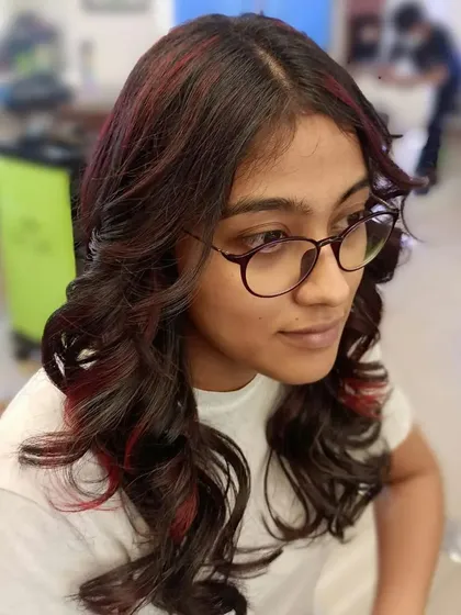This student's work showcases soft curls combined with subtle red highlights. You will learn how to place color strategically to enhance a haircut and add dimension.