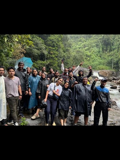 A group photo at a waterfall in Wayanad, with everyone enjoying the cool spray and natural beauty.