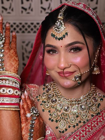 A classic bridal pose. This shot highlights the hand jewelry and the flawless makeup, from the defined eyes to the soft, radiant blush.