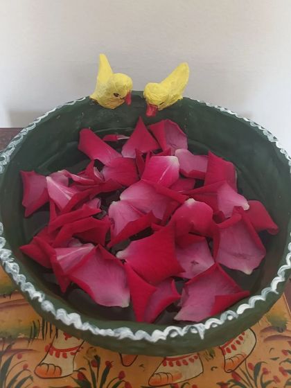 A student's creation of a bowl with two little yellow birds perched on the rim, perfect for holding floating flowers.