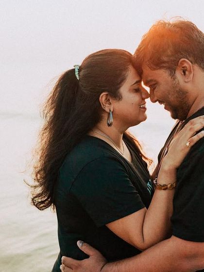 An intimate close-up against the bright, hazy light of the sea. This photo focuses purely on the couple's connection, shutting out the world around them.