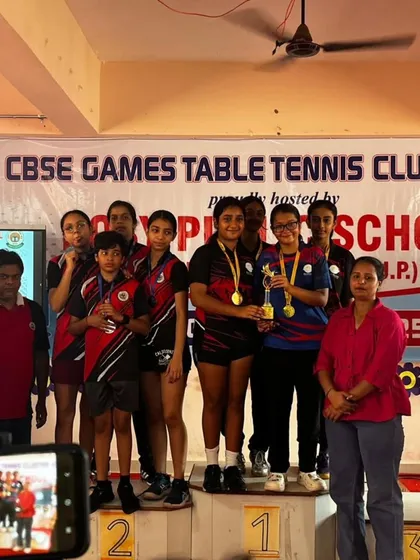 A group photo of our victorious girls' team on the podium at the CBSE Cluster Championship, celebrating a clean sweep.