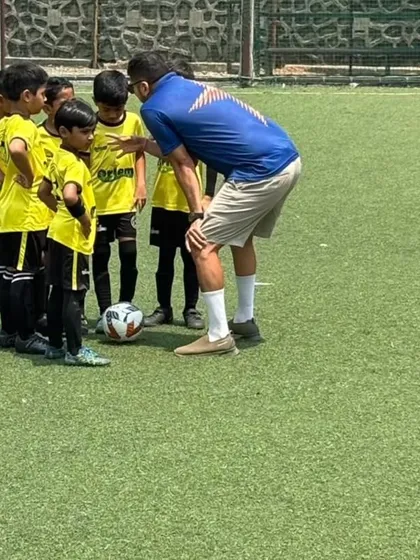 A coach giving a quick team talk to the U-7s during a break. Even at this age, we teach them to listen, learn, and play as a team.