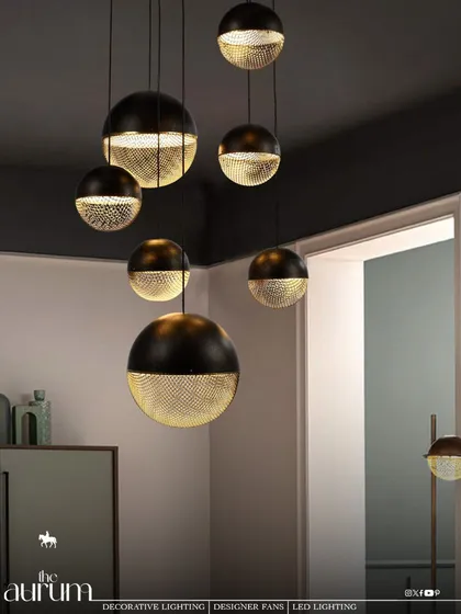 I love playing with contrast. This cluster of modern pendant lights, with their dual-tone black and perforated gold finish, creates a dramatic and moody atmosphere. They are perfect for adding a touch of sophisticated, masculine energy over a dining area or in a lounge.