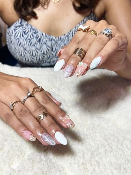 A beautiful mix of textures and colors, including solid white, pink, and full-coverage glitter nails with 3D accents.