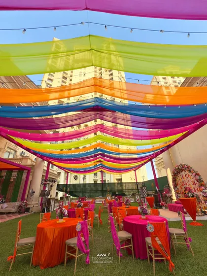 Another angle of the colorful draped ceiling, showing the scale of the setup against the building behind it.