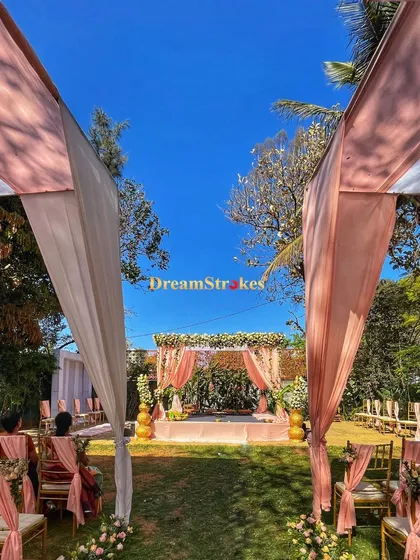 A wide shot of the wedding aisle, showing the guest seating and the beautiful canopy structure that provides shade and elegance for a daytime event.