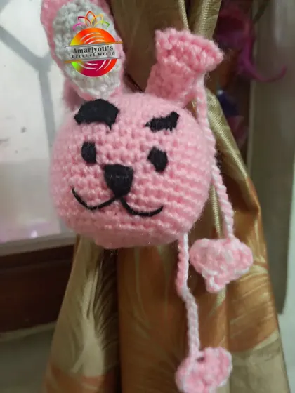 A playful bunny curtain tie-back, crocheted in a soft pink. This amigurumi-style holder adds a fun, storybook feel, perfect for a child's room.