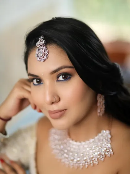 A close-up portrait showcasing the flawless base and striking blue eyeliner. This look is perfect for the modern bride who wants to make a statement.