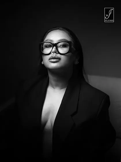 A bold, black and white portrait that emphasizes form and attitude. The dramatic side lighting and minimalist approach create a powerful, artistic statement piece for a model's portfolio or a brand campaign.