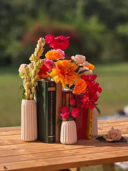 A creative centerpiece for our 'Artistic Atelier' Haldi, using books as a stand for a vibrant bouquet of flowers. This reflects the couple's love for art in a unique way.
