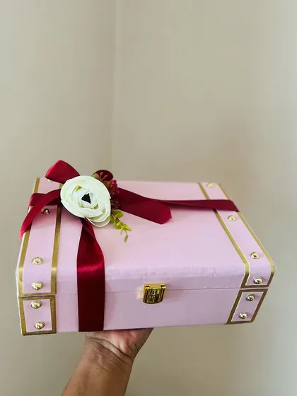 The packaging is the first impression. This beautiful pink and gold trunk box, held in hand, shows the quality and elegance of my premium options before you even see the curated gifts inside.