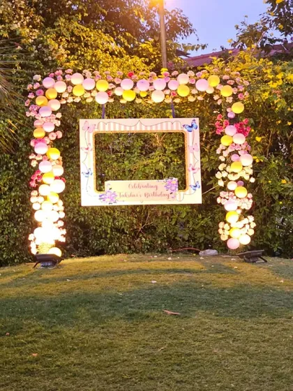 The same beautiful photo booth setup, now illuminated at night. We use spotlights to ensure the decor looks just as stunning after the sun goes down, so your party can continue in style.