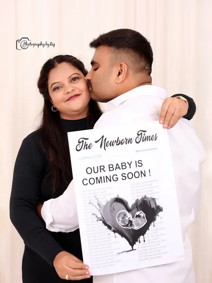 A creative pregnancy announcement photo using a custom "The Newborn Times" newspaper prop in our studio.