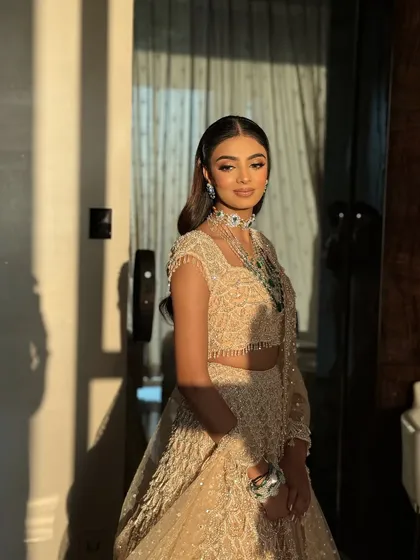 The play of light and shadow in this photo highlights the glowing skin and shimmery details of the makeup. This is a key technique for evening looks.