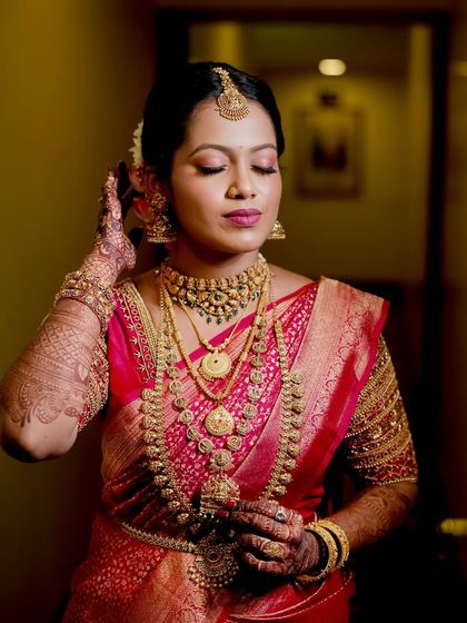 My bride Lavanya looked absolutely divine in her traditional pink South Indian saree. This shot captures a quiet moment of reflection, with the soft makeup enhancing her serene expression.