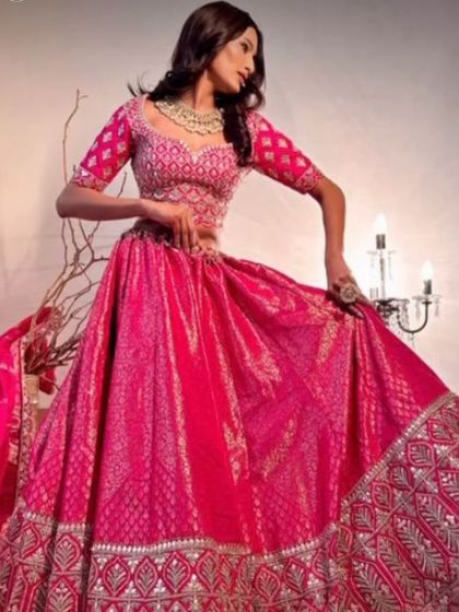 A full shot of the magenta Banarasi lehenga, highlighting its beautiful flare and color. This is a perfect rental for making a grand entrance.