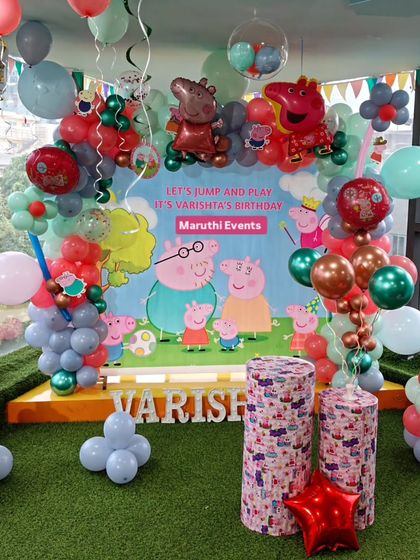 A 'Let's Jump and Play' Peppa Pig party for Varishita's birthday, with a large backdrop and balloon decorations in muted tones.