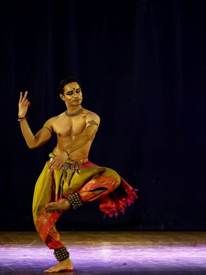 A full-stage view of a solo piece in Pune. The colorful costume and focused lighting help create the right atmosphere for the story being told.