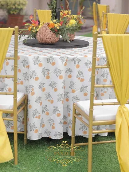 A detail shot of the guest table, showing the custom-printed tablecloth and yellow chair ties that bring the color theme to life.