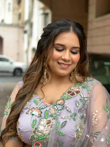 Dolled up for her Roka ceremony. This look features a soft lavender eyeshadow, beautifully defined eyes, and a flawless base, paired with a floral half-up hairstyle.
