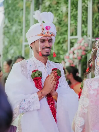 A candid moment capturing the groom's happy expression as he greets the bride.