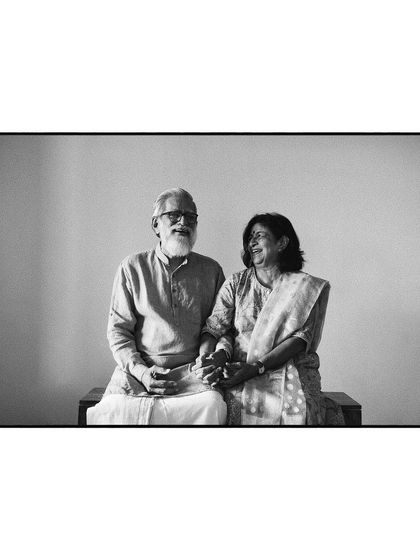 An elegant black and white portrait of a couple. The simple background and their gentle interaction create a timeless and heartfelt image.