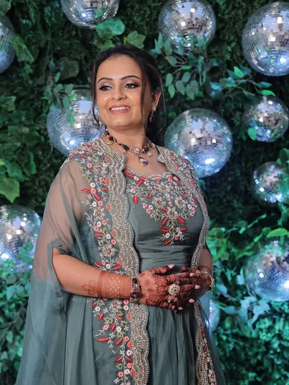 A full view of the client enjoying her engagement party, looking radiant and confident with her coral-hued makeup.