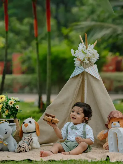 This outdoor first birthday shoot features a rustic, bohemian theme with a canvas teepee and stuffed animal friends, creating a charming setting for this little boy's celebration.