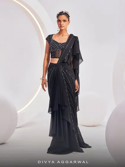 Designed for today and inspired by tradition, the Nerio Saree Set in black offers pre-draped elegance. The embellished finish and modern silhouette bring refined ease to cocktail dressing.