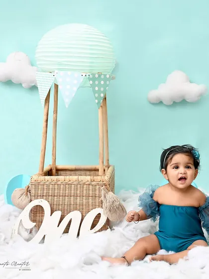 A look of wonder from this little adventurer. The soft pastel colors of the hot air balloon and clouds create a gentle and dreamy first birthday scene.