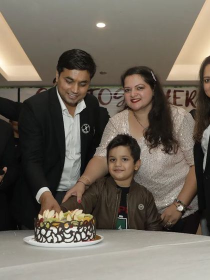 Cutting the cake with my wife and son, surrounded by my professional family. It's a beautiful blend of my personal and professional life.