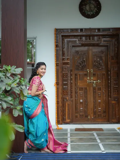 We also arrange shoots at beautiful outdoor locations. Here's a shot from a traditional Nauvari saree photoshoot at a partner farm studio in Panvel, using their stunning carved wooden door as a backdrop for an authentic feel.