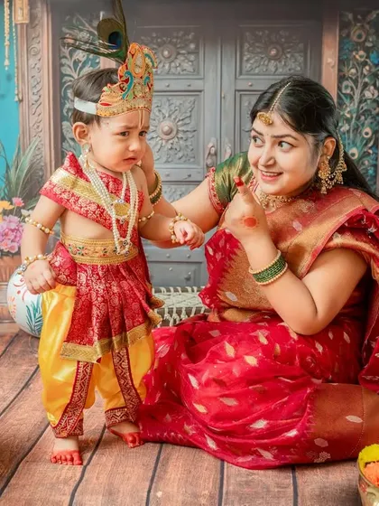 A candid moment of the baby looking a bit grumpy while his mother smiles lovingly, showing the real and funny side of baby photoshoots.