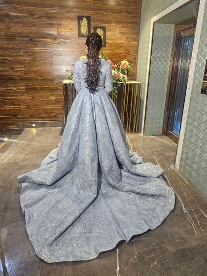 The back of this stunning grey engagement gown. The intricate hairstyle with a long, flowing ponytail adds to the drama.