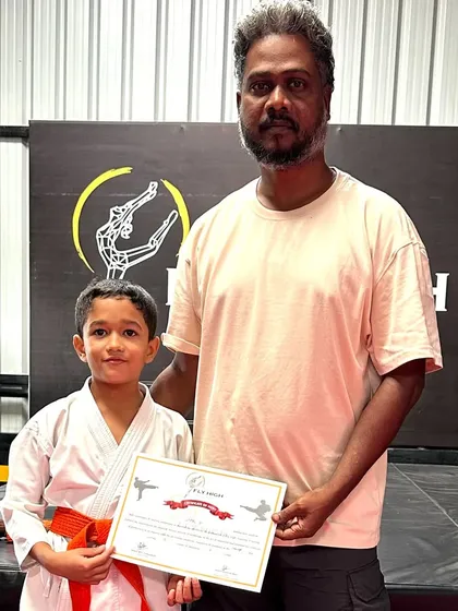 This student proudly holds his new orange belt and certificate. Our belt exams are a formal recognition of the skills and discipline our students develop in their karate training.