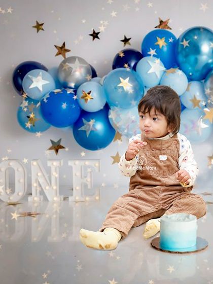 A "Twinkle Twinkle Little Star" first birthday. The starry blue balloons and light-up "ONE" sign create a magical atmosphere for this little one's cake smash.