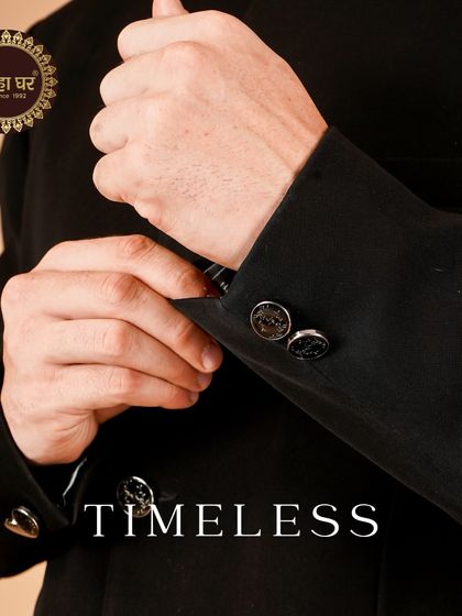 Timeless. A close-up on the sleeve and buttons of a classic black suit, emphasizing the fine details.