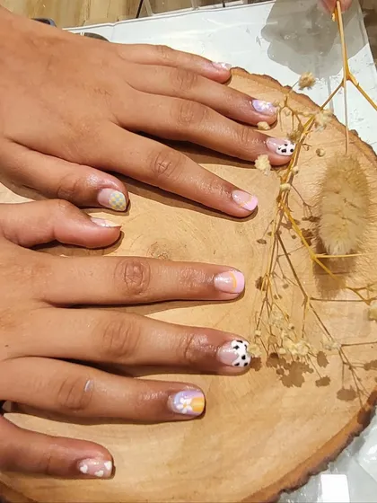 A collection of cute summer-themed nail art. This set includes a mix of designs like cow print, plaid, and florals on a pastel base for a fun and eclectic look.