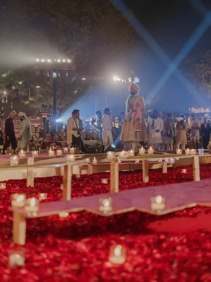 The groom's path to the mandap is lined with countless candles and a carpet of red rose petals. This is how I transform a simple walkway into a deeply romantic and symbolic journey.
