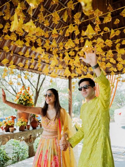 The couple waves happily as they walk into their Haldi ceremony, ready for the celebration.