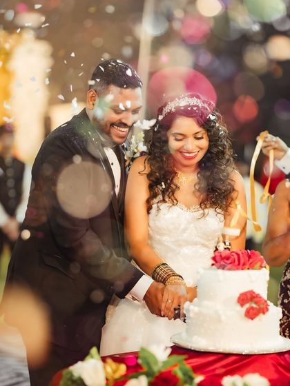 The joyful cake cutting ceremony, complete with a shower of confetti. This photo captures the happiness and celebration of one of the reception's key moments.
