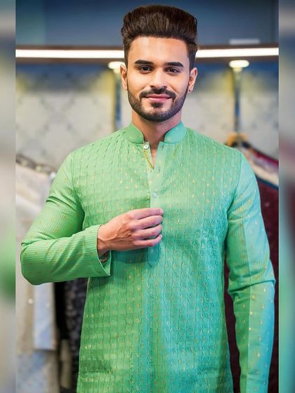 A client, Ayush Khatri, looking pleased in a bright green textured kurta. The fit is perfect, highlighting the benefits of custom tailoring.