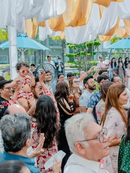 A wide shot of the crowd enjoying the pool party, with even the youngest guests having a great time.