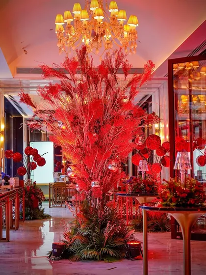 A towering centerpiece made of red-dyed foliage. This dramatic installation served as a major focal point in the room, adding to the bold and eclectic theme.